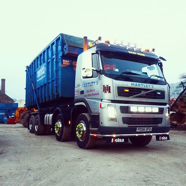 skip hire truck with extra large skip loaded on the back